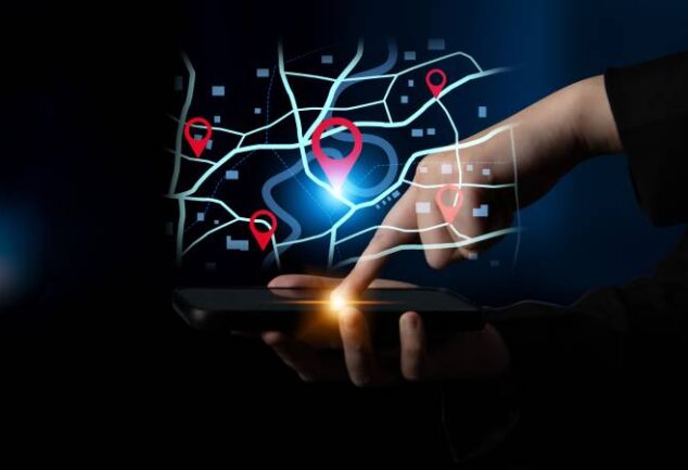 Mão de usuário operando smartphone com interface de mapa digital e pins de geolocalização flutuantes, demonstrando o uso do otimizador de rotas do Google para planejamento logístico avançado.