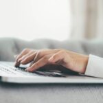 Gemini no Google Chat_ IA para Resumir Conversas Mão em close-up utilizando um computador portátil. Uso da tecnologia de conexão online para negócios, educação e comunicação.