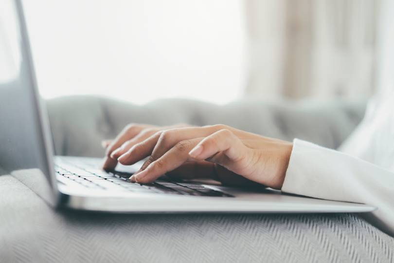 Mão em close-up utilizando um computador portátil. Uso da tecnologia de conexão online para negócios, educação e comunicação.