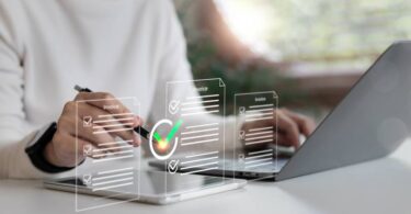 Close de mãos assinando faturas digitais com selo de verificação verde, destacando a segurança e validade jurídica da assinatura eletrônica em ambiente corporativo.