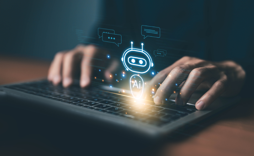 Close de usuário interagindo com computador onde surge um ícone de robô com a inscrição "AI", representando a integração de sistemas de IA corporativa para suporte e eficiência operacional.